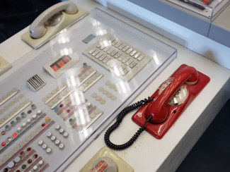 A red emergency phone on a control panel at a nuclear power plant