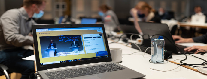 A laptop in the foreground at the sub-areas expert conference on 17 and 18 October 2020 and people working in the background.