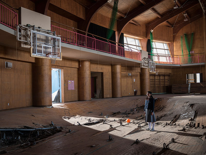 Girl standing in destroyed gym in Fukushima